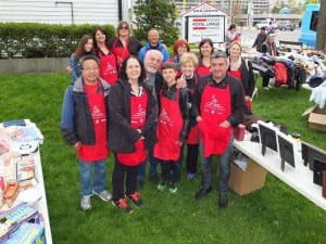 Royal LePage volunteers in company aprons pose at the 2017 garage sale.
