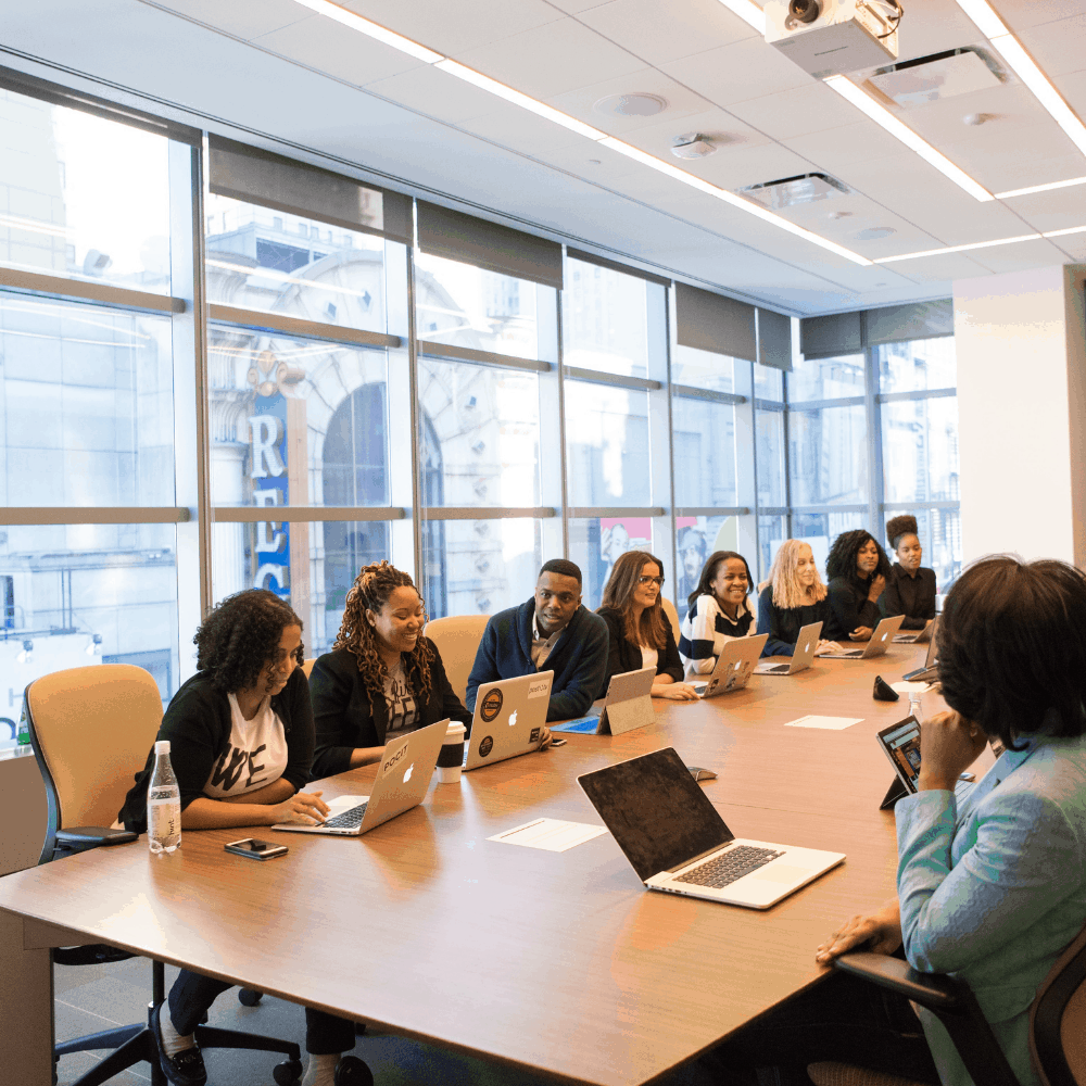 Women sit around a boardroom table.