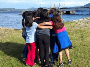 Image of girls in a circle with arms around each other 