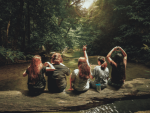 Girls sitting on log in forest