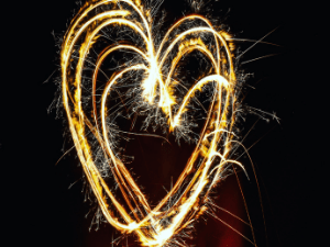 Image of heart made by sparkler against dark sky